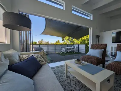 a living room with a couch and a table at 116m² SeaView TopLuxury Apart, Bay & Mountain View in Somerset West