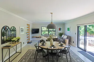 a living room with a table and chairs at Saffron House in Hermanus