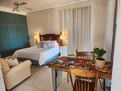 a bedroom with a bed and a table and a couch at Stirling House in Paarl