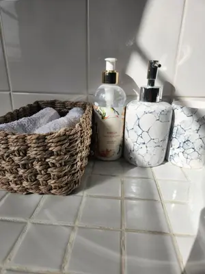 a bathroom counter with two bottles of soap and a basket at Stirling House in Paarl