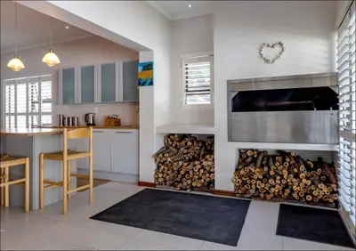 a kitchen with a pile of firewood in a fireplace at Seabreeze in Hermanus