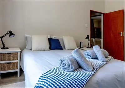 a bedroom with a bed with towels on it at Seabreeze in Hermanus