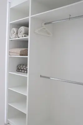 a white closet with white shelves and towels at Nivenia Beach House in Bettyʼs Bay