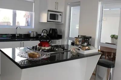 a kitchen with a stove with a tea kettle on it at Nivenia Beach House in Bettyʼs Bay