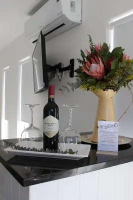 a counter with two bottles of wine and two glasses at Nivenia Beach House in Bettyʼs Bay
