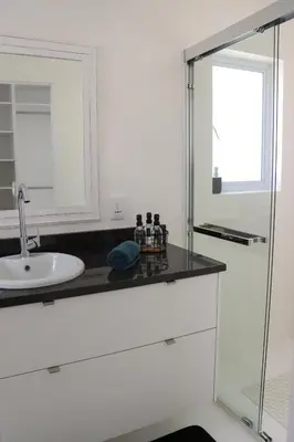 a bathroom with a sink and a mirror at Nivenia Beach House in Bettyʼs Bay
