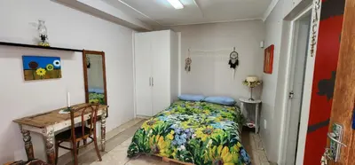a bedroom with a bed and a table and a desk at Sundance in Central Greyton in Greyton