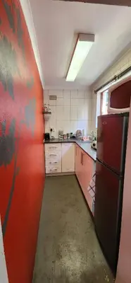 a kitchen with a refrigerator and a red wall at Sundance in Central Greyton in Greyton