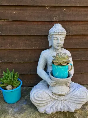 a statue of a person holding a plant in a vase at PONDOKKIE in Greyton