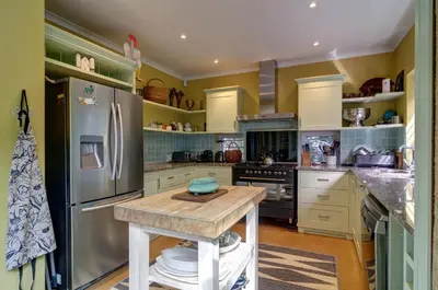 a kitchen with a stainless steel refrigerator and a wooden table at Dieu Donne in Hermanus