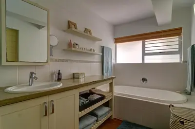 a bathroom with a sink and a tub and a mirror at Dieu Donne in Hermanus