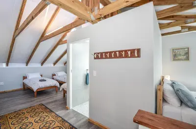 a room with white walls and wooden beams at The Neighbours - Kleinmond in Kleinmond