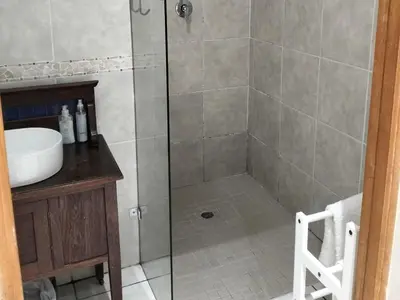 a shower with a glass door in a bathroom at Hermanus 13 on 2nd Guest Rooms in Hermanus