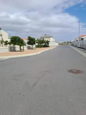an empty street in a town with trees and buildings at Modest Home in Cape Town in Cape Town