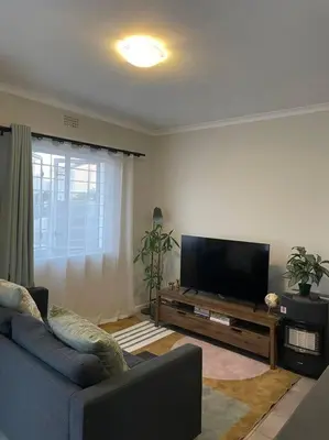a living room with a couch and a flat screen tv at Modest Home in Cape Town in Cape Town
