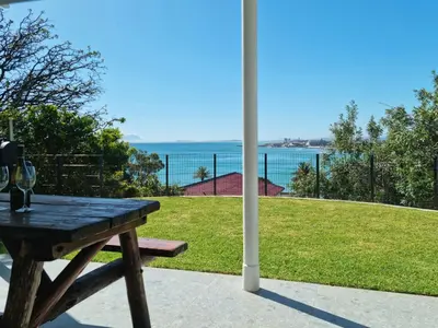 a picnic table with a view of the ocean at 'BoStrand' - Private and Central, only 2 min walk to beach - sleeps 2 in Gordonʼs Bay