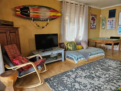 a living room with a couch and a tv at Cardamom Cottage, sleeps 3 and 1 min walk to beach in Cape Town