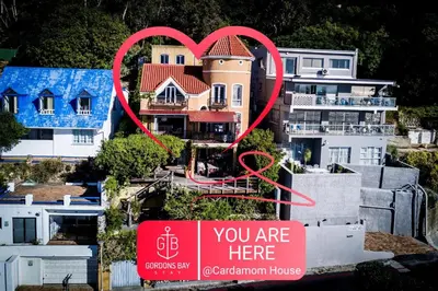 a house with a heart sign in front of it at Cardamom Cottage, sleeps 3 and 1 min walk to beach in Cape Town