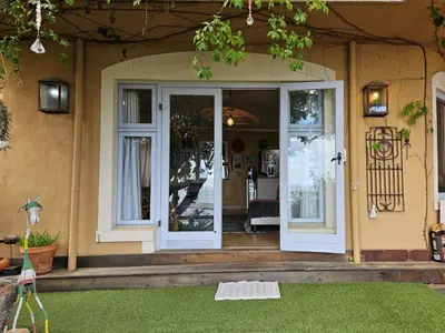 a front door of a house with a porch at Cardamom Cottage, sleeps 3 and 1 min walk to beach in Cape Town