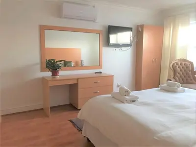 a bedroom with a bed with a desk and a mirror at The Other House - Cape Town in Cape Town
