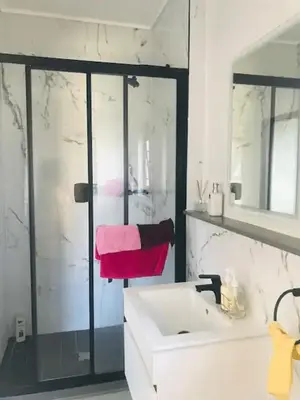 a white bathroom with a sink and a shower at Luxurious Lifestyle in Cape Town