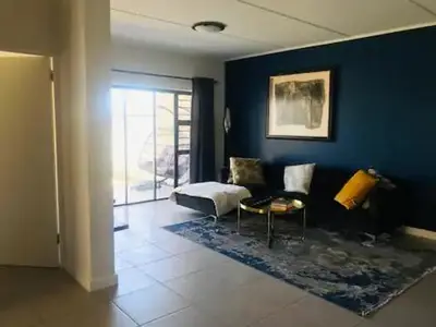 a blue room with a bed and a chair at Luxurious Lifestyle in Cape Town