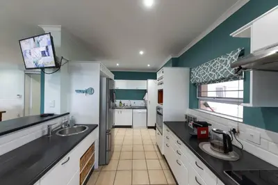 a kitchen with a sink and a counter top at 'Ocean Views', Modern, Spacious Home, 3 En-suite Bedrooms in Cape Town