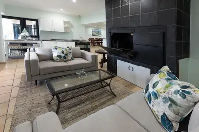 a living room with a couch and a tv at 'Ocean Views', Modern, Spacious Home, 3 En-suite Bedrooms in Cape Town