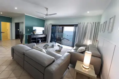 a living room with a couch and a television at 'Ocean Views', Modern, Spacious Home, 3 En-suite Bedrooms in Cape Town