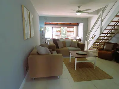 a living room with a couch and a table at 'Terrace-On-Sea'- 2 Min from the beach, 2 bedroom town house, Sleeps 4 in Cape Town