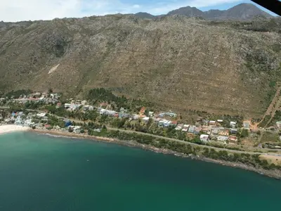 an aerial view of a beach next to the water at '75 Protea' 4 Bedroom Holiday Home for 8 with Private Pool and Ocean Views in Cape Town