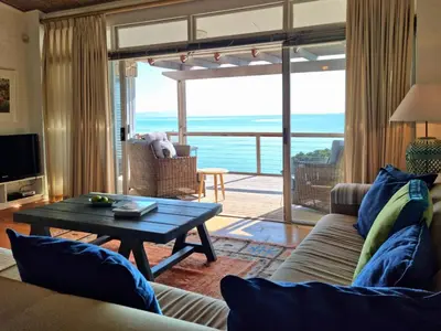 a living room with a couch and a table at '75 Protea' 4 Bedroom Holiday Home for 8 with Private Pool and Ocean Views in Cape Town