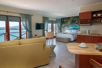a living room with a couch and a bed in a room at Le Gaulois Luxury Apartments, sleeps 2, Sea Views in Gordonʼs Bay