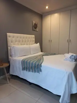 a bedroom with a large bed with white sheets at Freys 1 in Cape Town