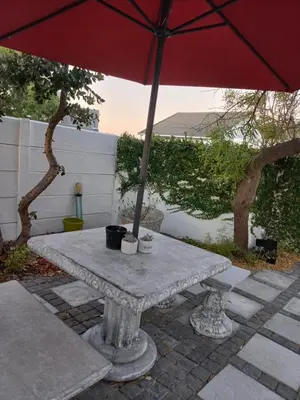 a stone table with an umbrella on a patio at Freys 1 in Cape Town