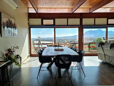 a dining room with a table and chairs and a large window at 'The Loft', 2 bedroom, sleeps 4, Central, Fantastic Views! in Cape Town