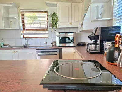 a kitchen with a counter top with a glass table at 'The Loft', 2 bedroom, sleeps 4, Central, Fantastic Views! in Cape Town
