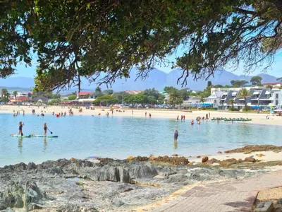 a group of people swimming in the water on a beach at 'The Loft', 2 bedroom, sleeps 4, Central, Fantastic Views! in Cape Town