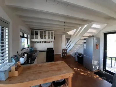 a kitchen with a wooden table in a room at Peaceful Seaside Cottage, Betty's Bay Accommodation in Clareport