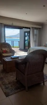a living room with a couch and a coffee table at Driftwood Beach Villa in Gordonʼs Bay