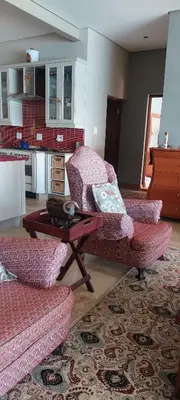 a living room with two chairs and a coffee table at Driftwood Beach Villa in Gordonʼs Bay