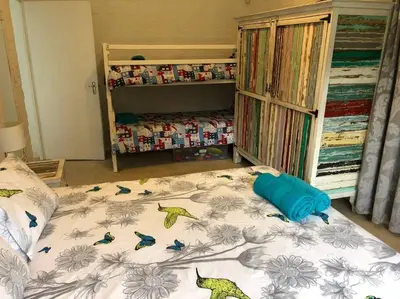 a bedroom with a bed with birds on it at Rustica in Onrus close to the beach in Hermanus