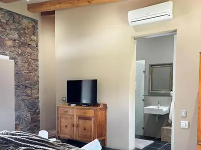 a bathroom with a tv on a dresser with a sink at Nooitgedacht Guest Farm Cottages in Kayamnandi