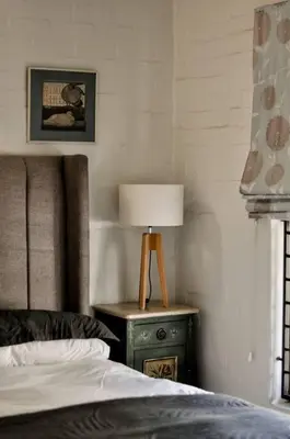 a bedroom with a bed and a lamp on a night stand at Mar-a-Stella Self-Catering Family Retreat in Bettyʼs Bay