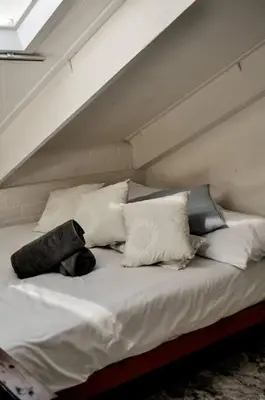 a bed with white pillows on top of it at Mar-a-Stella Self-Catering Family Retreat in Bettyʼs Bay
