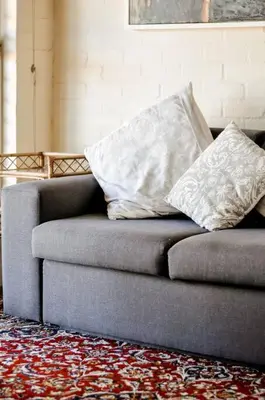 a couch with two pillows on it in a room at Mar-a-Stella Self-Catering Family Retreat in Bettyʼs Bay