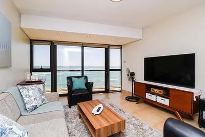 a living room with a flat screen tv and a couch at 302 Ocean View in Strand
