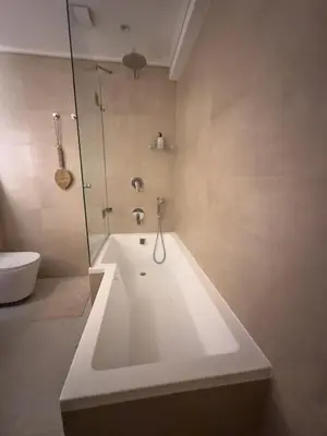 a white bath tub in a bathroom with a shower at Happy Dolphin - Luxury 3BR Sea View Apartment in Cape Town