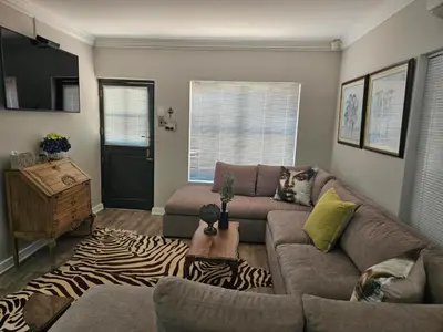 a living room with a couch and a zebra rug at At 37 Masters Way in Brandwacht