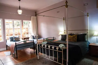 a bedroom with a four poster bed and a couch at Greyton Toad Hall Historic Private House in Central Greyton in Greyton